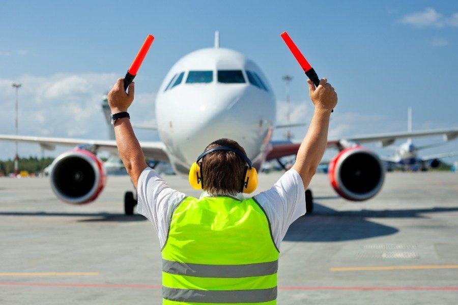 Airport ground crew worker with clipboard by aircraft